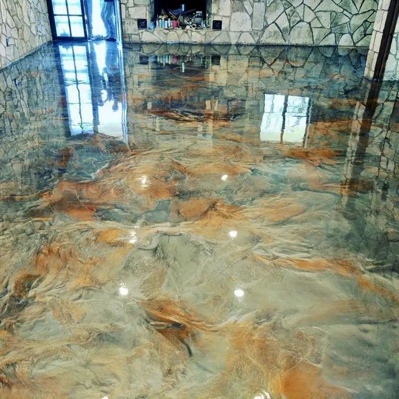 Glossy copper and silver metallic epoxy flooring in a rustic stone-walled room.